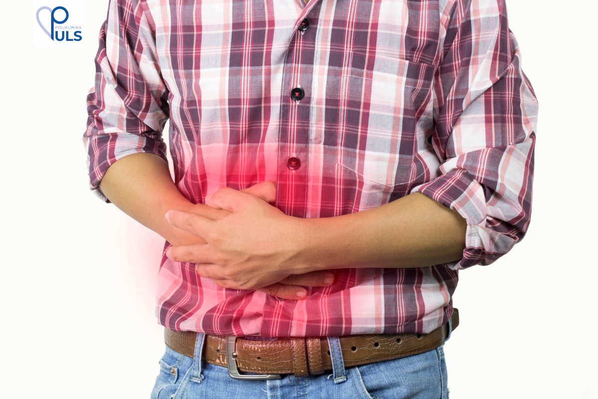 Bol u stomaku. Osoba drži ruke na stomaku zbog boli 